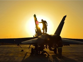 Royal Canadian Air Force ground crew perform post flight checks on a CF-18 fighter jet in Kuwait after a sortie over Iraq during Operation IMPACT on November 3, 2014.   Photo: Canadian Forces Combat Camera, DND IS2014-5026-03 ORG XMIT: IS2014-5026 ORG XMIT: POS1411041252298866  // na121214-CF18s     // na121214-CF18s