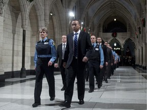 Samearn Son marches with House of Commons security personnel through the Hall of Honour as they make their way to be honoured in the House of Commons for their efforts during the October shooting on Parliament Hill, Thursday, December 11, 2014 in Ottawa.