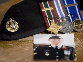 A photo of Cpl. Stuart Langridge is seen along with his beret and medals.