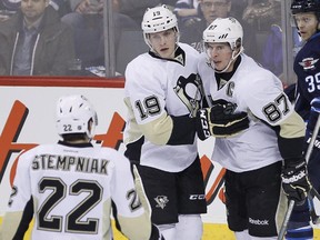 Pittsburgh Penguins' Lee Stempniak (22), Beau Bennett (19) and Sidney Crosby (87) celebrate Bennett's goal against the Winnipeg Jets' as Jets' Tobias Enstrom (39) looks on during first period NHL action in Winnipeg on Thursday, April 3, 2014. All three have now either contracted mumps or been isolated and tested for it.