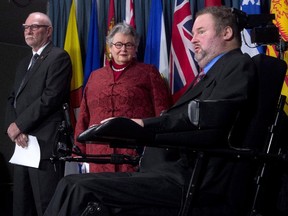 Sen. Nancy Ruth (centre) and Sen. Larry Campbell listen to MP Steven Fletcher discuss physician-assisted death legislation during a news conference in December, 2014.