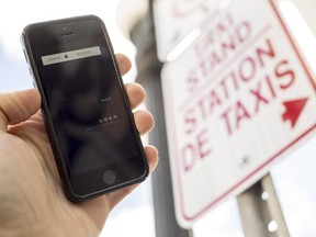 The UBER app is photographed with taxis in the background on Dalhousie St. in Ottawa Thursday September 11, 2014. (Darren Brown/Ottawa Citizen)