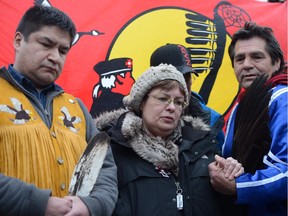 Attawapiskat Chief Theresa Spence holds hands with supporters during a press conference outside her teepee on Victoria Island in January, 2013. Spence was on a protest hunger strike at the time.