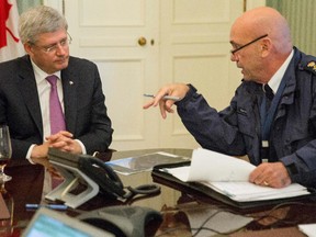 RCMP Chief Bob Paulson briefs Prime Minister Stephen Harper on the shootings at Parliament Hill in Ottawa on Wednesday Oct. 22, 2014.