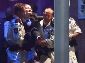Injured hostage Marcia Mikhael is carried out of a cafe in the central business district of Sydney on December 16, 2014. Westpac, a University of Ottawa alumna who works for an Australian financial institution, was rescued when police stormed the Sydney cafe where a gunman had taken hostages and displayed an Islamic flag.