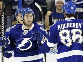 Tampa Bay Lightning center Tyler Johnson, left, celebrates his goal against the Pittsburgh Penguins with teammate right wing Nikita Kucherov, right, of Russia, during the first period of an NHL hockey game Tuesday, Dec. 23, 2014, in Tampa, Fla.