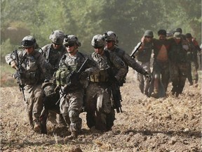 U.S. Army soldiers carry a wounded American soldier to a U.S. Army helicopter, June 28, 2010,  near Kandahar, Afghanistan.