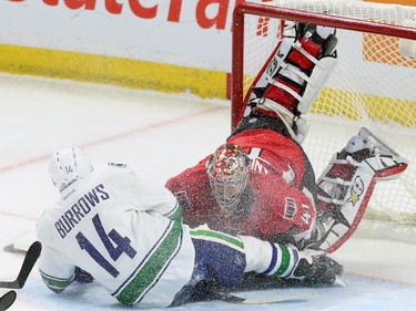 Vancouver Canucks' Alexandre Burrows(14) collides with Ottawa Senator goaltender Craig Anderson (41) during NHL first period action in Ottawa Sunday, December 7, 2014.