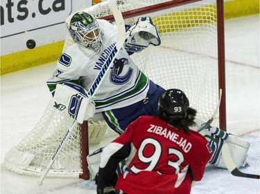 Vancouver Canucks goaltender Eddie Lack (30) blocks a shot as Ottawa Senators' Mika Zibanejad looks for a rebound during NHL first period action in Ottawa Sunday, December 7, 2014.