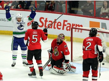 Vancouver Canucks' Hendrik Sedin (33) celebrates a Vancouver goal against the Ottawa Senators goalie Craig Anderson as Senators' Cody Ceci (5) and Jared Cowen (2) look on during NHL first period action in Ottawa Sunday, December 7, 2014.