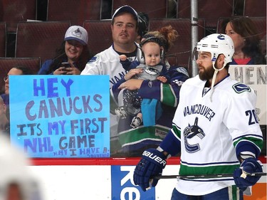 An infant taking in his first NHL game looks at Chris Higgins #20 of the Vancouver Canucks during warmup prior to a game against the Ottawa Senators at Canadian Tire Centre on December 7, 2014 in Ottawa, Ontario, Canada.