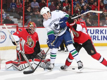 Craig Anderson #41 of the Ottawa Senators makes a pad save against Derek Dorsett #51 of the Vancouver Canucks as Mark Borowiecki #74 of the Ottawa Senators defends the net during an NHL game at Canadian Tire Centre on December 7, 2014 in Ottawa, Ontario, Canada.