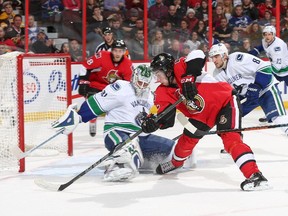 Mika Zibanejad #93 of the Ottawa Senators backhands the puck past Eddie Lack #31 of the Vancouver Canucks for his second goal of the game as Chris Tanev #8 of the Vancouver Canucks looks on the Vancouver Canucks in the second period during an NHL game at Canadian Tire Centre on December 7, 2014 in Ottawa, Ontario, Canada.