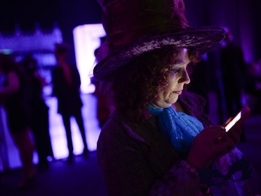 A woman checks her cell phone during The Mad  Hatter's New Year's Ball by National Capital Gala at the Ernst & Young Centre on Wednesday, Dec. 31, 2014. (James Park / Ottawa Citizen)