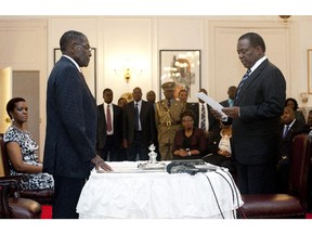 Zimbabwe's newly appointed vice president Emmerson Mnangagwa (R) takes the oath of office before President Robert Mugabe (L) at the State House in Harare on December 12, 2014. Zimbabwe's Justice Minister Emmerson Mnangagwa, a long-time ally of Mugabe, was sworn in as vice president, putting him firmly in line to succeed the veteran ruler.