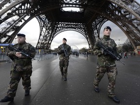 TOPSHOTS  French soldiers patrol in front of the Eiffel Tower on January 8, 2015 in Paris as the capital was placed under the highest alert status a day after heavily armed gunmen shouting Islamist slogans stormed French satirical newspaper Charlie Hebdo and shot dead at least 12 people in the deadliest attack in France in four decades. A  huge manhunt for two brothers suspected of massacring 12 people in an Islamist attack at a satirical French weekly zeroed in on a northern town Thursday after the discovery of one of the getaway cars. As thousands of police tightened their net, the country marked a rare national day of mourning for Wednesday's bloodbath at Charlie Hebdo magazine in Paris, the worst terrorist attack in France for half a century. AFP PHOTO / BERTRAND GUAYBERTRAND GUAY/AFP/Getty Images
