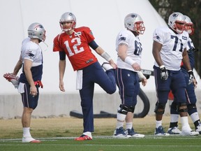 New England Patriots quarterback Tom Brady (12) stretches with teammates during practice Wednesday, Jan. 28, 2015, in Tempe, Ariz.