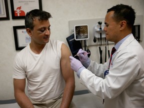Gautam Gupta receives an influenza shot from  Nurse Practitioner Ray Grigorio at a clinic in Florida.