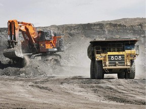 A haul truck carrying a full load drives away from a mining shovel at the Shell Albian Sands oilsands mine near Fort McMurray, Alta., Wednesday, July 9, 2008.