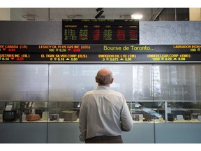 A man watches the financial numbers at the TMX Group in Toronto's financial district in a May 9, 2014 photo.