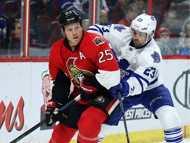 Chris Neil of the Ottawa Senators battles against Trevor Smith of the Toronto Maple Leafs during first period NHL action.