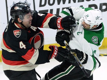 Ottawa Senators' Chris Phillips (4) pushes Dallas Stars' Jamie Benn during second period NHL hockey action.