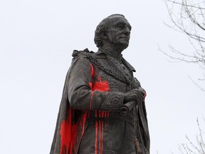 City of Kingston employees remove graffiti on the statue of Sir John A. MacDonald, Canada's first prime minister, in City Park in Kingston, Ont. on Friday Jan. 11, 2013.