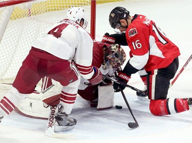 Ottawa Senators' Clarke MacArthur (16) fights for possession of the puck as Arizona Coyotes' goaltender Mike Smith(41) attempts to smother the puck as teammate Zbynek Michalek (4) reacts during first period NHL hockey action in Ottawa on Saturday January 31, 2015.