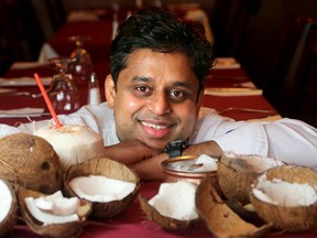 Coconut Lagoon's owner, chef JoeThottungal, shows how easy it is to open a mature coconut, remove the meat and make coconut milk from scratch. Coconut milk should not be confused with coconut water, which comes from young coconuts, like the one left with a straw in it.
