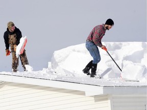 Keep an eye on your roof's snow load. D.J. Schloss, left, and Doug Metz, right shovel off a roof in Alden, N.Y. on Nov. 20. The weight of the snow has caused problems around the area with roofs collapsing and buildings compromised.