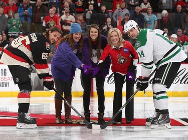 Left to right: Erik Karlsson #65 of the Ottawa Senators poses for a ceremonial face-off with Clara Hughes, Anonda Hoppner, Stephanie Richardson and Jamie Benn #14 of the Dallas Stars on Do It For Daron (D.I.F.D.) Youth Mental Health Awareness Night at Canadian Tire Centre.