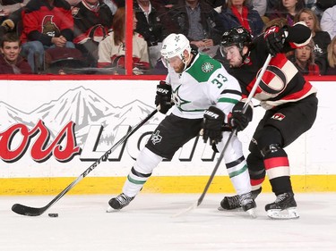 Alex Goligoski #33 of the Dallas Stars stickhandles the puck as Mika Zibanejad #93 of the Ottawa Senators defends on the back-check.