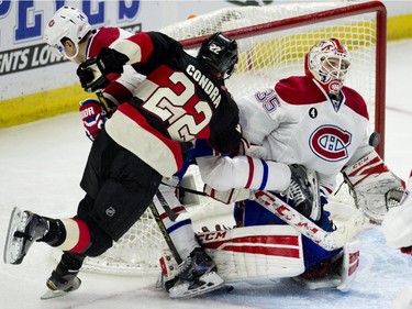 Montreal Canadiens goalie Dustin Tokarski makes a save as teammate defenceman Alexei Emelin and Ottawa Senators right wing Erik Condra crash into him during third period NHL action.