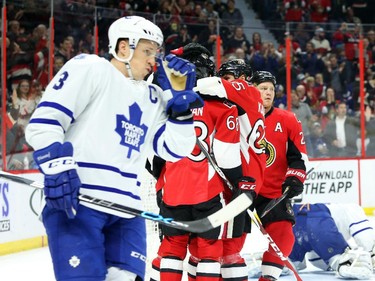 Erik Karlsson of the Ottawa Senators celebrates his goal with his team as Dion Phaneuf of the Toronto Maple Leafs skates by dejected during first period NHL action.