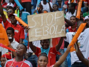 A football fan holds a placard reading "Stop Ebola in Africa" ahead of the 2015 African Cup of Nations group A football match between Equatorial Guinea and Congo at Bata Stadium in Bata on Saturday.