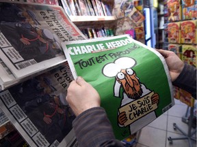 A man displays the latest edition of French satirical magazine Charlie Hebdo shortly after it went on sale on January 14, 2015 in Montpellier, France.