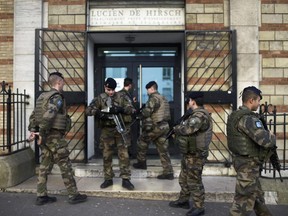French soldiers patrol on January 14, 2015 in front of a school in Paris, as France announced an unprecedented deployment of thousands of troops and police to bolster security at "sensitive" sites following last week's jihadist attacks in Paris.