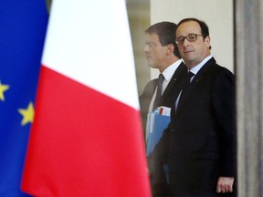 French President François Hollande (R) and French Prime Minister Manuel Valls walk at the Elysee Palace after a security meeting on January 12, 2015 in Paris.
