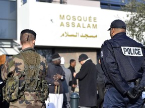 A French soldier and a police officer stand guard in front of the Assalam mosque at the end of the Friday pryaer on January 23, 2015 in the western French city of Nantes.