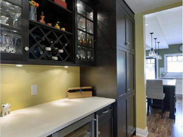 A hallway between the kitchen and dining room doubles as a butler’s pantry, with wine fridge, serving counter and glass and pantry storage.