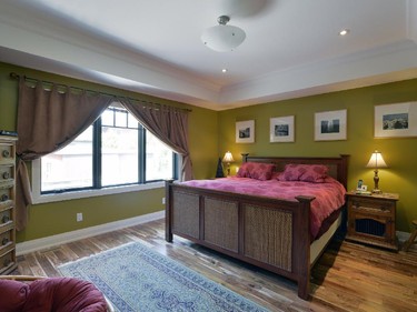 The large master bedroom is welcoming in a rich olive green.