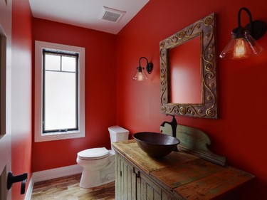 Not shy of colour, a powder room is bold in red.