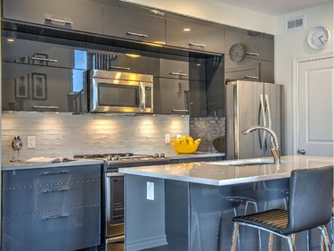 In the Cardiff kitchen, gleaming black kitchen cupboards with horizontal doors (an upgrade) are the star attraction. They’re set off by a glass tile backsplash and light-toned granite countertops and island.