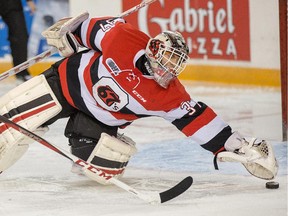 Goalie Leo Lazarev jumps on the puck in the first period.