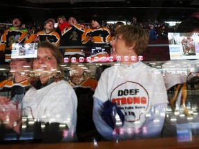 Hockey moms of the Smith Falls Bears players wait rinkside for the start of a ceremony at an Ottawa 67's game on January 18, 2015, raising awareness and support for Neil Doef, a hockey player with the Smiths Falls Bears, who was severely injured during a recent game.