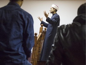 Imam Mohamed Jebara  leads a prayer service in the basement of Human Concern International in Ottawa Friday, October 24, 2014.