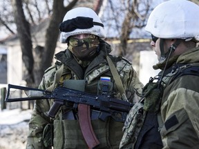 In this Thursday, Jan. 15, 2015 photo, pro-Russian rebels stand on guard near their position in the Donetsk airport in Donetsk, Eastern Ukraine.