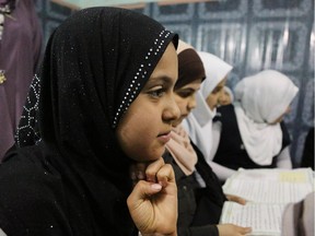 In this Thursday, March 13, 2014 photo, girls study at an orphanage in Baghdad, Iraq, Thursday, March 13, 2013. The director of the shelter says that she will not allow marriage of minors at her orphanage, despite a contentious civil status draft law for Iraqi Shiite community that allows child marriage and restricts women's rights. Canada has signalled its intention to work to end child marriage.