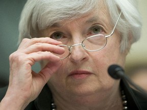 In this July 16, 2014 file photo, Federal Reserve Chair Janet Yellen removes her glasses as she testifies on Capitol Hill in Washington before the House Financial Services Committee. The Fed's quantitative easing program ended in October.