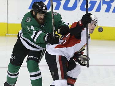 Ottawa Senators center Jean-Gabriel Pageau (44) and Dallas Stars defenseman Jordie Benn (24) fight for control of the puck during the second period of an NHL hockey game Tuesday, Jan. 13, 2015, in Dallas.